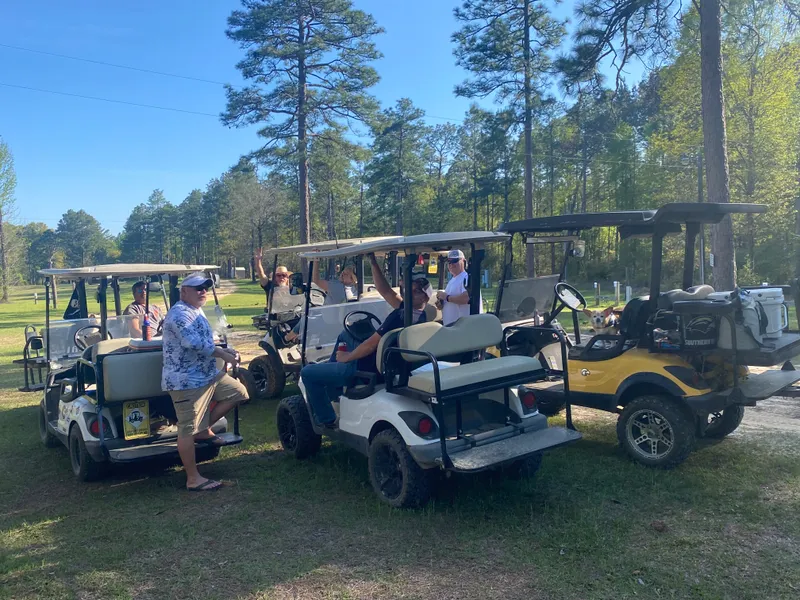 Friends gathered with golf carts among the pines at Lodge #599