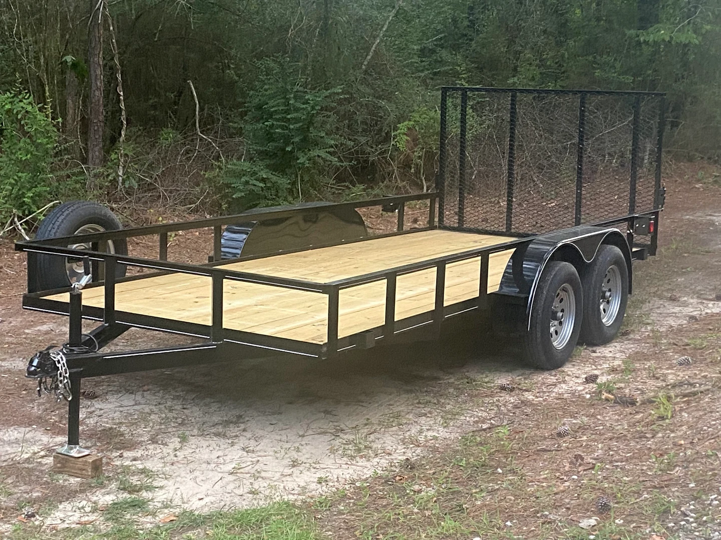 16-foot tandem-axle utility trailer with wood deck and upright mesh gate